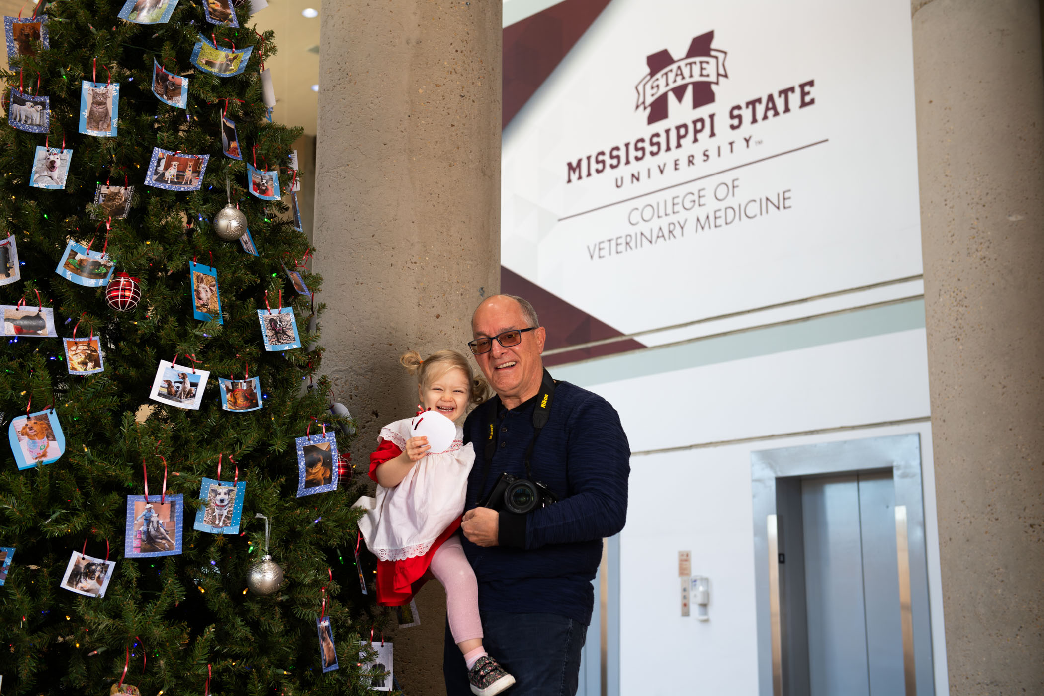 Tom Thompson, pictured holding his granddaughter next to a Christmas tree 